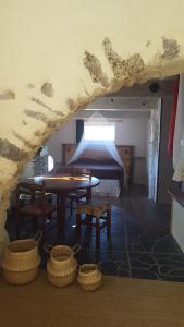 Zimmer mit einem Bett, einem Tisch und Körben in der Unterkunft Gîte dans ancienne bergerie en pleine garrigue in Fraissé-des-Corbières