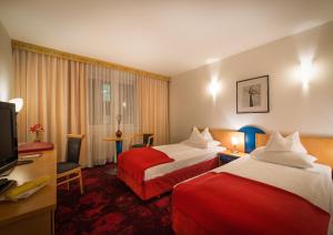 Una habitación de hotel con dos camas y un televisor. en Hotel Boltzmann, en Viena