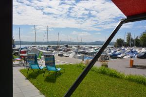 vistas a un puerto deportivo con sillas y barcos en Leben im Hafen am idyllischen Murtensee, en Guévaux