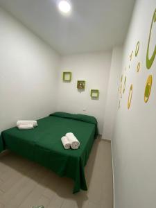 カステッランマーレ・デル・ゴルフォにあるCasa fragolaのベッドルーム1室(緑色のベッド1台、タオル2枚付)
