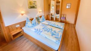 um quarto com uma cama azul com almofadas azuis em Gästehaus Rader em Weissbriach