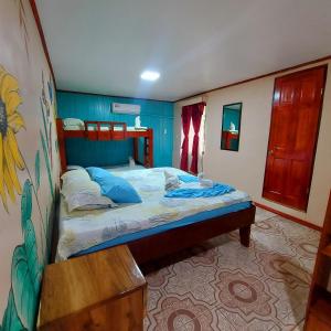a small bedroom with a bed with blue walls at Hotel Gitana Corcovado, y Tour operador in Drake