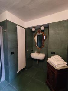 Cascina Flino - Tra le vigne - Appartamento 2 في ألبا: حمام مع حوض ومرآة على الحائط