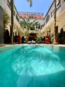 een groot zwembad in een gebouw met palmbomen bij Riad Pachavana in Marrakesh