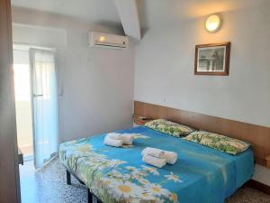 a bedroom with a blue bed with towels on it at Hotel Amalfi in Rimini