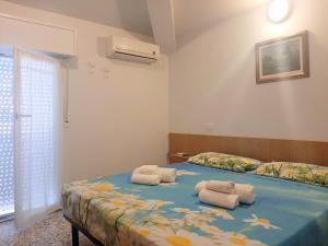 a bedroom with two beds with towels on it at Hotel Amalfi in Rimini