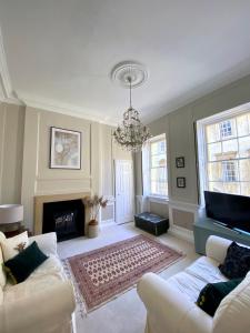 a living room with two couches and a fireplace at Exclusive Georgian apartment in centre of Bath in Bath