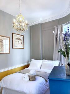 a bedroom with two beds and a chandelier at Exclusive Georgian apartment in centre of Bath in Bath