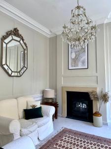 a living room with a white couch and a chandelier at Exclusive Georgian apartment in centre of Bath in Bath