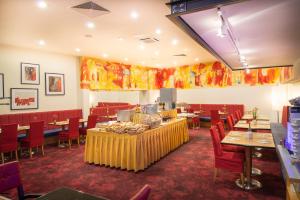 un comedor con mesas y sillas rojas en Hotel Boltzmann, en Viena