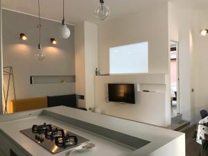 una cucina con piano cottura e una TV a parete di CaseOspitali - RAFFAELLA moderno bilo vicino al SAN RAFFAELE a Segrate
