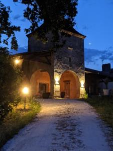 an old stone building with lights on a road at Au Clair de Vianne Ce sont les petits détails qui font la différence in Vianne