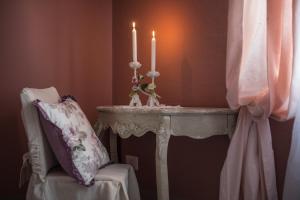 a table with two candles on it next to a chair at B&B Il Biancospino in Abbadia San Salvatore