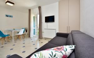a living room with a couch and a table at in olive garden in Starigrad-Paklenica
