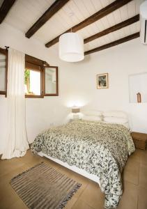 een slaapkamer met een bed in een witte kamer bij Casa De Los Cuadros in Villaluenga del Rosario