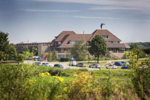 un grand bâtiment avec des voitures garées dans un parking dans l'établissement Van der Valk Hotel Stein Urmond, à Urmond