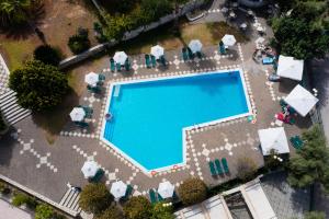 an overhead view of a swimming pool with chairs and umbrellas at Santa Marina Hotel in Agios Nikitas