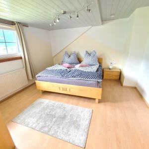 een slaapkamer met een bed met kussens en een tapijt bij Ferienwohnungen Claudia in Altossiach