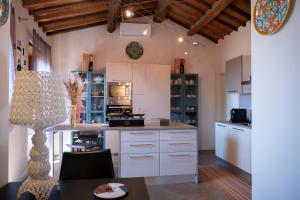 a large kitchen with white cabinets and a table at Cathedral-luxury-stay sauna & massage in Pescia