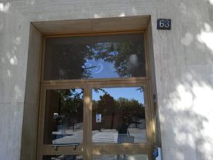 eine Glastür eines Gebäudes mit einem Schild darauf in der Unterkunft Simple & Comfortable apartment POLICLINICO SAN DONATO in San Donato Milanese