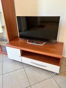 a flat screen tv on a wooden tv stand at Marzan 12 in Peschiera del Garda