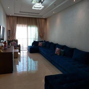 a living room with a blue couch and a table at Bouznika DREAMS in Bouznika