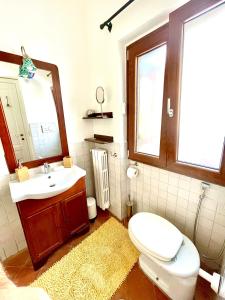 bagno con servizi igienici, lavandino e specchio di Relais Serapo a Gaeta