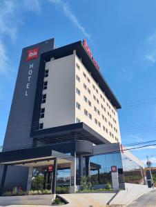 un hotel con un gran cartel en la parte delantera en ibis Nova Serrana, en Nova Serrana