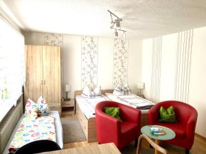 a room with a bed and two red chairs at Ferien in Sachsen in Bischofswerda