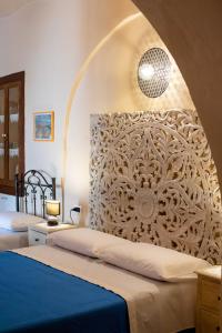 Aliano的住宿－Il Paesaggio Lunare，一间卧室设有两张床,墙上装饰有艺术作品