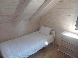 niewielka sypialnia z białym łóżkiem i oknem w obiekcie Manta domki letniskowe w Sianożętach