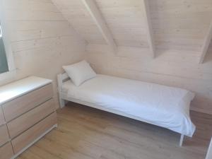 mały pokój z łóżkiem na poddaszu w obiekcie Manta domki letniskowe w Sianożętach