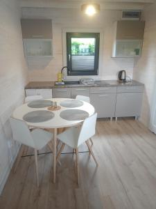 Manta domki letniskowe في سيانوزيتي: مطبخ مع طاولة وكراسي في غرفة