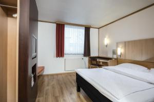 a hotel room with a bed and a desk at Good Morning Erfurt in Erfurt