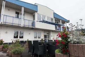 ein Gebäude mit Stühlen und Blumen davor in der Unterkunft Good Morning Erfurt in Erfurt