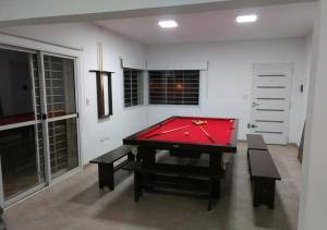 a ping pong table in a room with a red cloth at Alquiler temporal casa Bialet Masse con pileta, cancha de fútbol, mesa de pool y ping pong in Bialet Massé