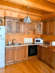 タターリウにあるMagnoliaのキッチン(木製キャビネット、シンク、冷蔵庫付)