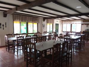 Hotel Espadan في Azuébar: غرفة طعام مع طاولات وكراسي ونوافذ