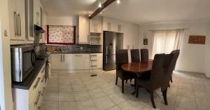 a kitchen with a wooden table and black chairs at Vinview 4-bedroom holiday home in Swakopmund