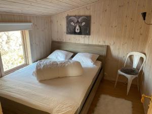 a bed in a room with a picture of a goat at Nissedal- en liten perle ved Nisser 