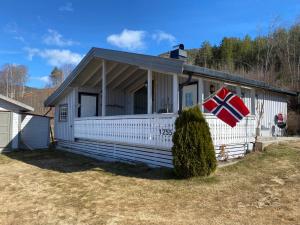 a house with a flag on the side of it at Nissedal- en liten perle ved Nisser 