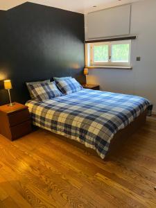 a bedroom with a bed with a plaid blanket and a window at bij Petros in Opglabbeek