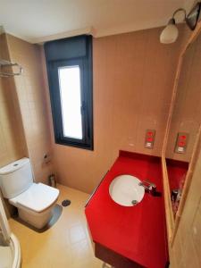 een badkamer met een rode wastafel en een toilet bij Loft Cabañaquinta in Aller
