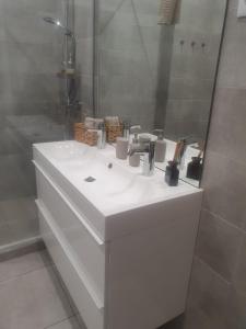 La salle de bains est pourvue d'un lavabo blanc et d'une douche. dans l'établissement Lisboa Central Apartment, à Lisbonne