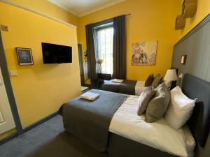 a hotel room with two beds and a television at The Residence - 47 Minto St in Edinburgh