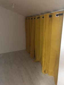 ein gelber Vorhang in einem Zimmer mit Holzboden in der Unterkunft studio (T1 bis) in Pessac