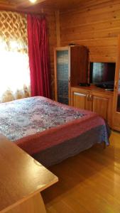 - une chambre avec un lit dans une cabane en rondins dans l'établissement Гостевой дом Azia, à Borovoe