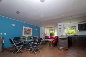 sala de estar con paredes azules, mesa y sillas en Cabaña Playa Caimán 1, en Coveñas