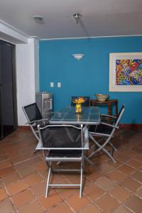 una mesa y sillas en una habitación con una pared azul en Cabaña Playa Caimán 1, en Coveñas