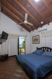 1 dormitorio con 1 cama azul y ventilador de techo en Cabaña Playa Caimán 1, en Coveñas